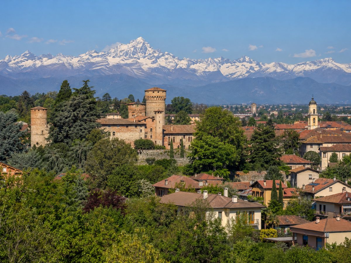 Rivalta di Torino con il castello tra gli alberi e le Alpi sullo sfondo