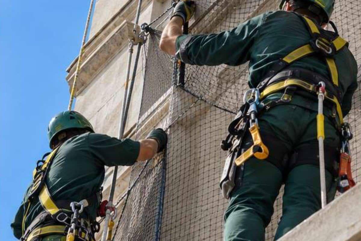 Tecnici Ekonore installano una rete anti volatili su una facciata